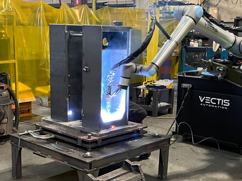 A cobot fabrication tool welding a base assembly