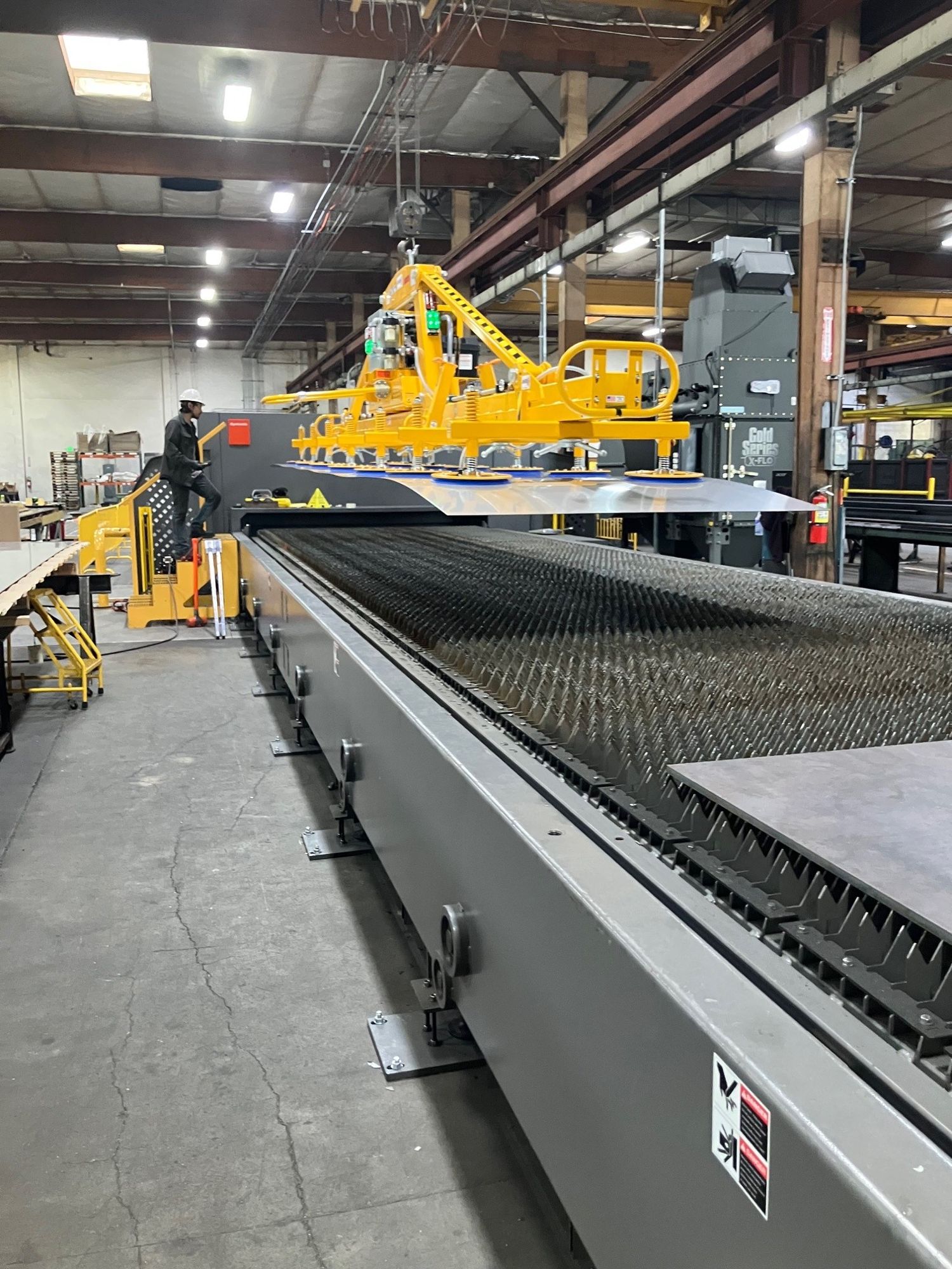 Sheet metal being loaded onto laser cut bed