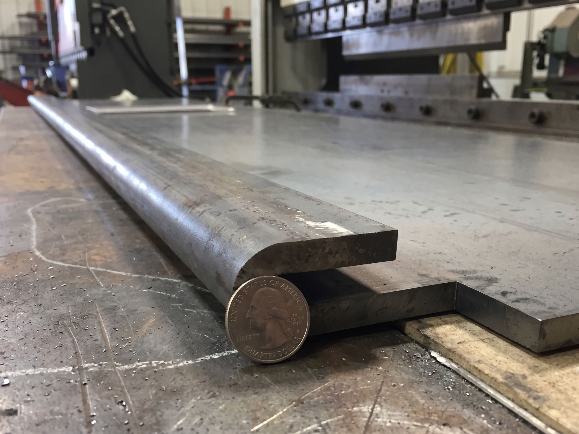 Precision press brake folded steel with a quarter in front for reference